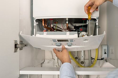 Heating technician repairing a residential boiler in Rancho Palos Verdes