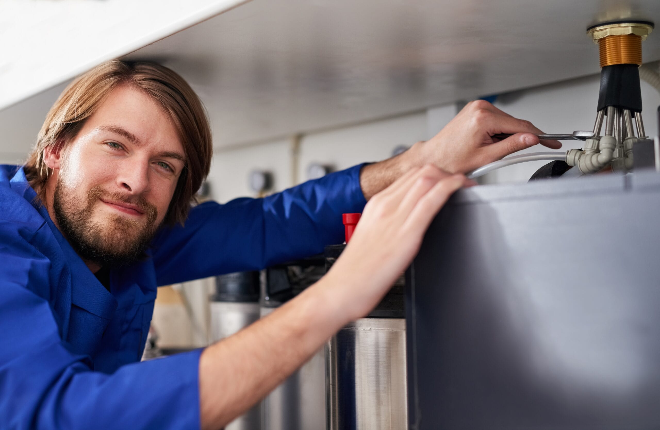 Technician servicing a residential water heater tank in Rancho Palos Verdes